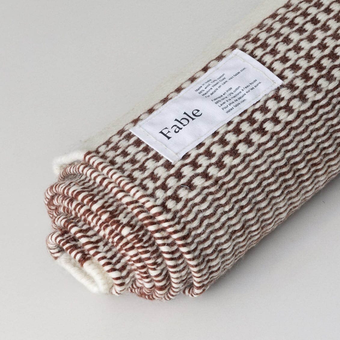 Folded fabric with 'Fable' label on a light gray background #burntsienna