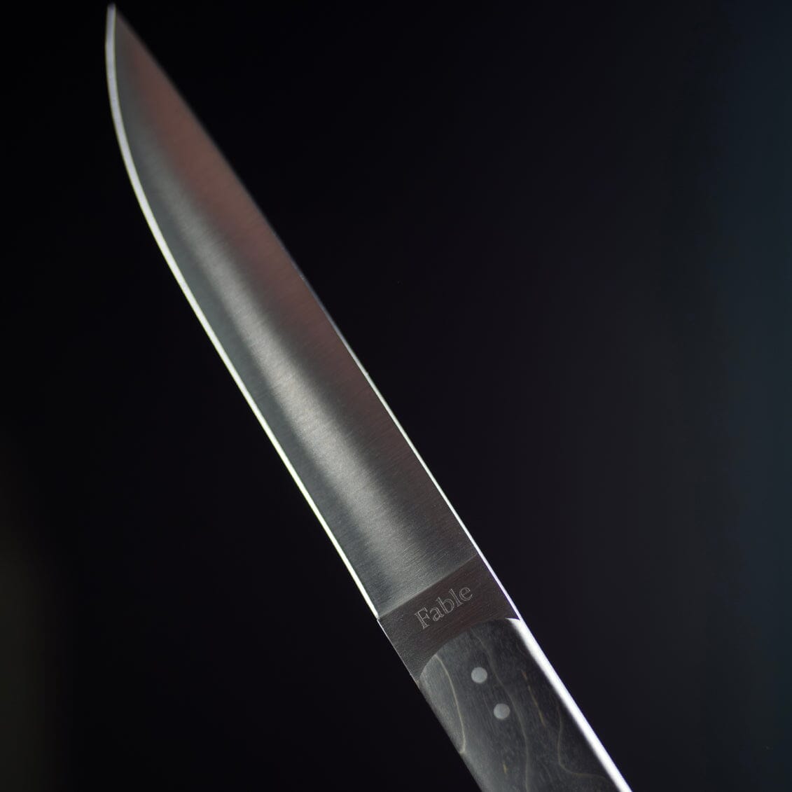Knife blade with 'Fable' branding on a dark background