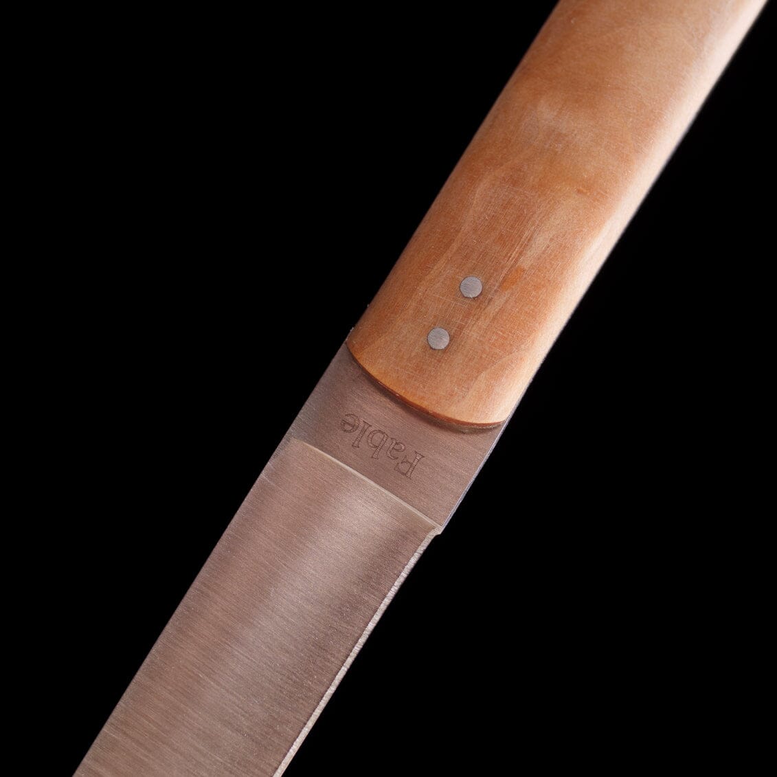 Close-up of a knife with a wooden handle on a black background